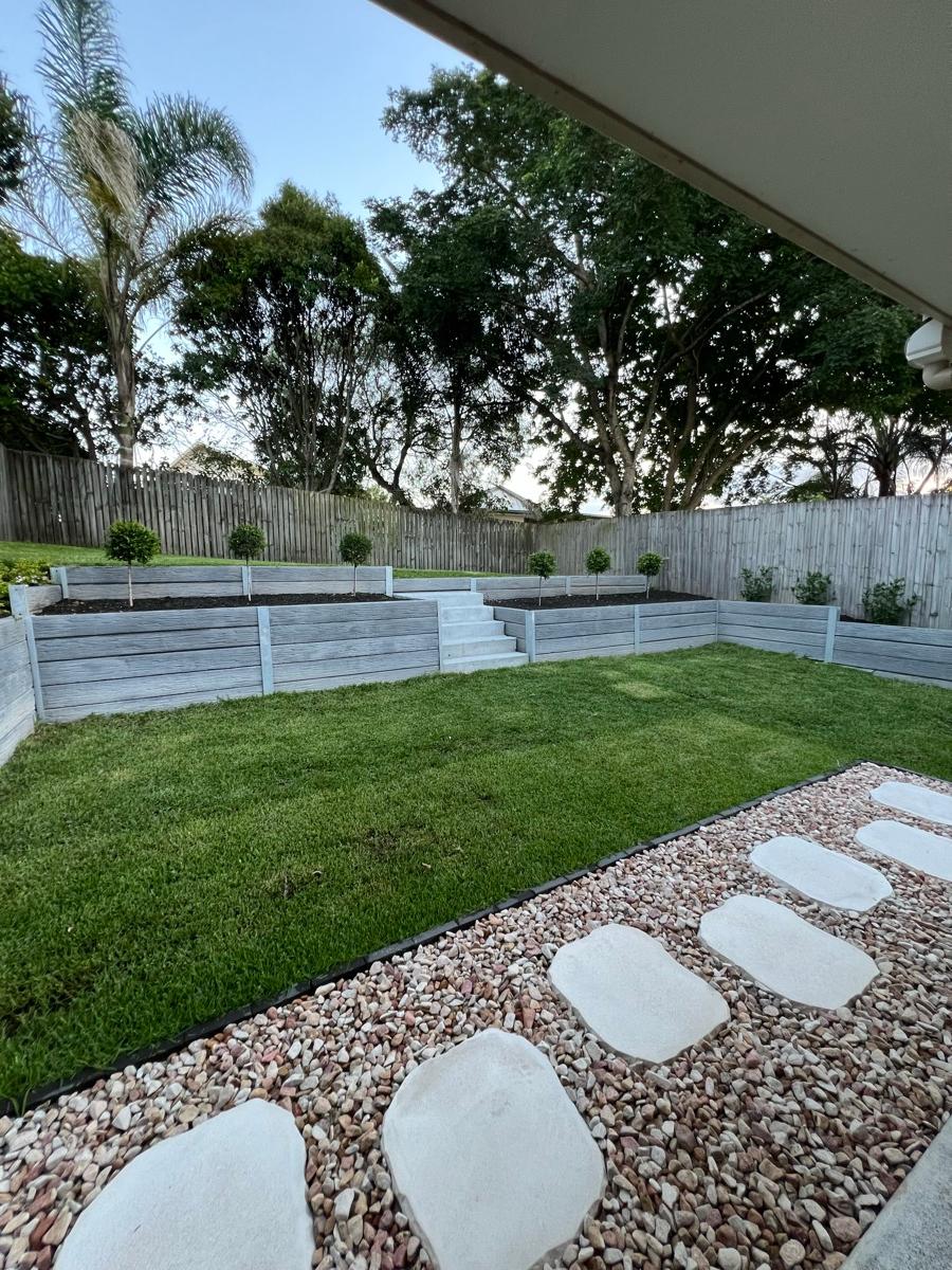 Lawn with stepping stones along a white fence