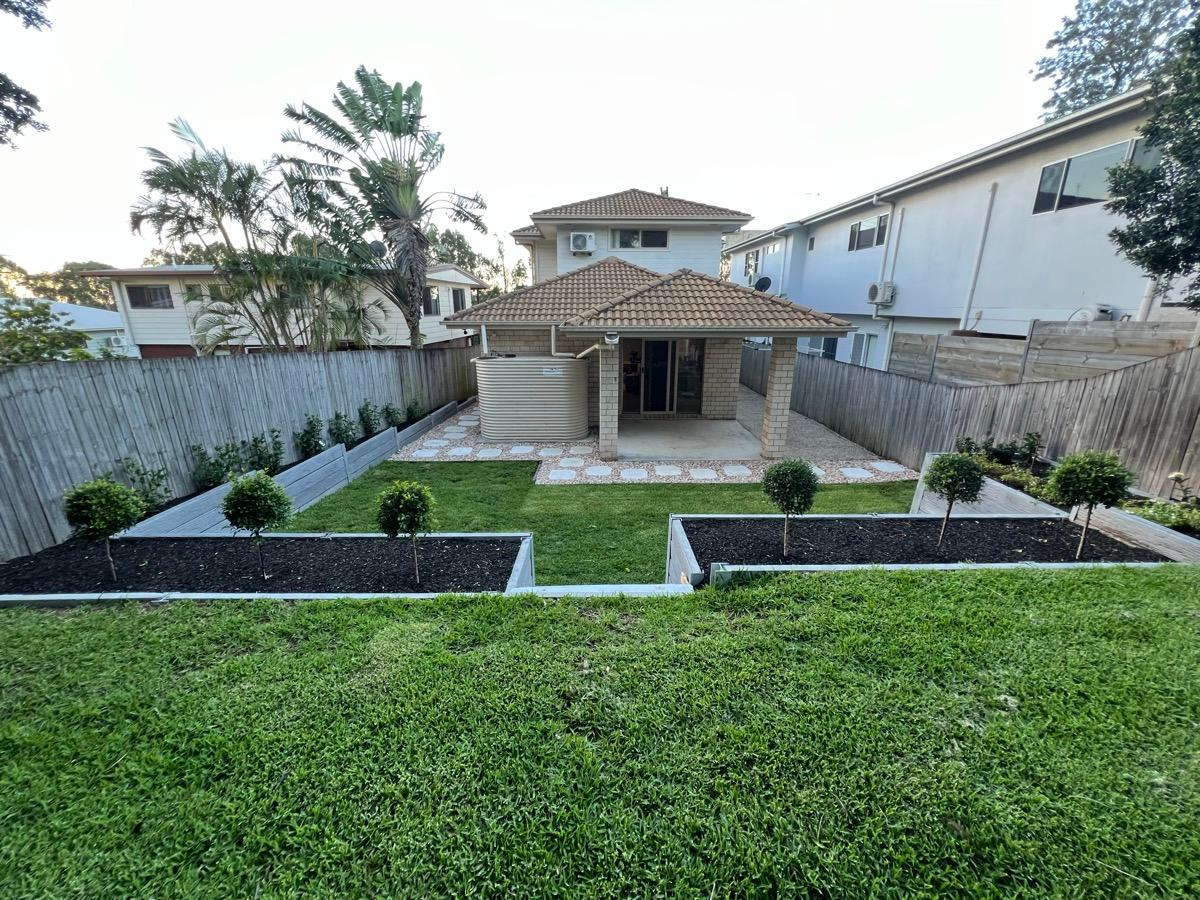 Full backyard lawn with fresh garden beds